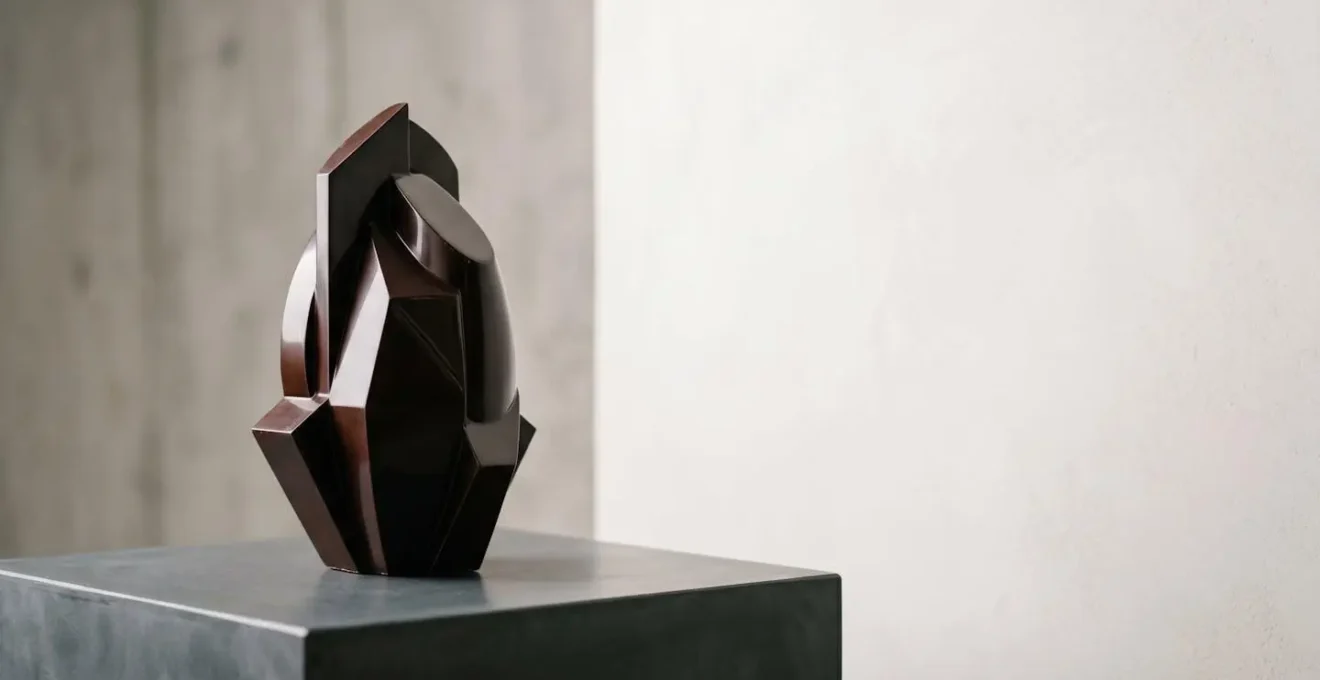 Sculpture en chocolat noir tempéré avec détails architecturaux délicats sur fond minimaliste