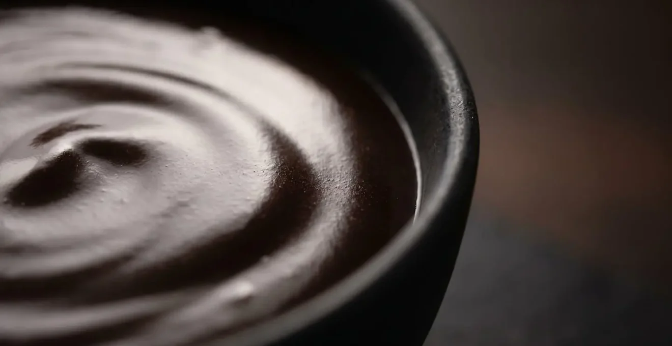 Ganache au chocolat noir avec texture miroir parfaite et émulsion stable, surface brillante réfléchissante