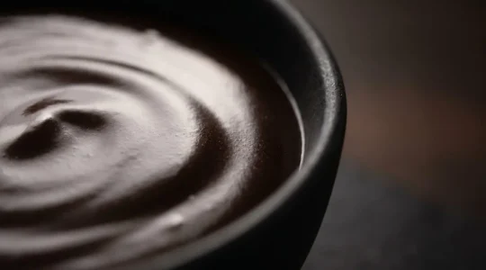 Ganache au chocolat noir avec texture miroir parfaite et émulsion stable, surface brillante réfléchissante