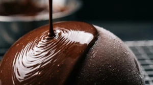 Entremets au chocolat recouvert d'un glaçage miroir parfaitement lisse et brillant, surface réfléchissante impeccable