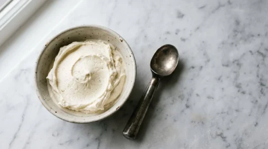 Glace vanille maison onctueuse dans un récipient artisanal avec texture crémeuse parfaite