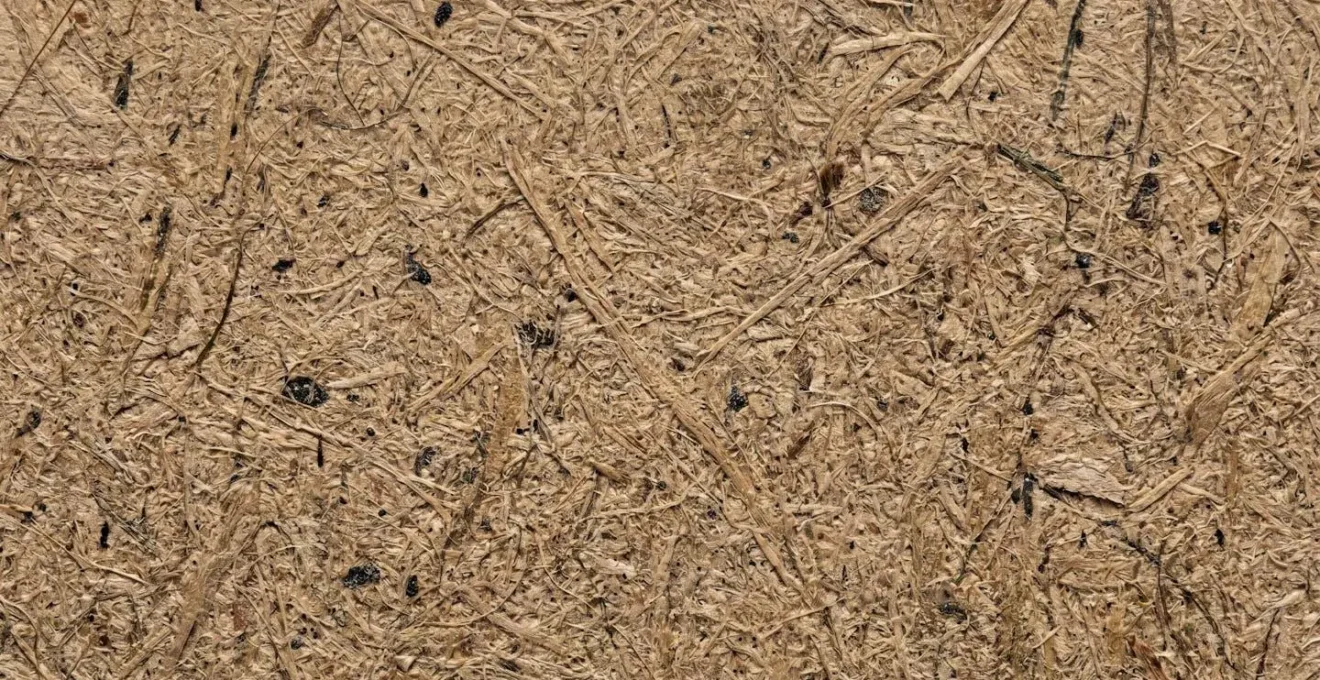 Gros plan extrême sur la texture d'un papier kraft recyclé montrant les fibres naturelles et le grain visible du matériau